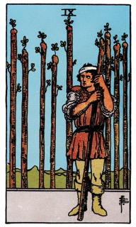 Rider–Waite Nine of Wands tarot card showing a guarded figure holding a wand, symbolizing resilience, persistence, and inner strength after challenges.